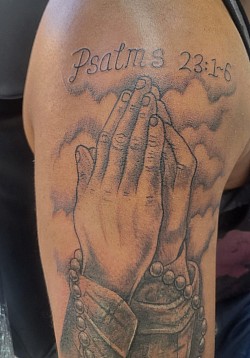 Praying hands tattoo cover up of football badge