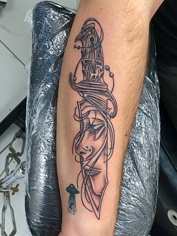 Blade with face tattoo on forearm